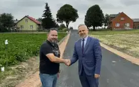 W&oacute;jt Gminy Kijewo Kr&oacute;lewskie wraz z przedstawicielem Przedsiębiorstwa Rob&oacute;t Drogowo &ndash; Budowlanych &bdquo;DROBUD&rdquo; podający sobie ręce na znak zakończenia inwestycji