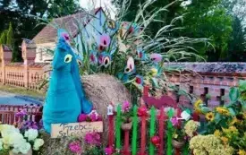 Sołectwo Trzebcz Szlachecki.Witacz przedstawiający pawia stojącego wsr&oacute;d kwiat&oacute;w i warzyw