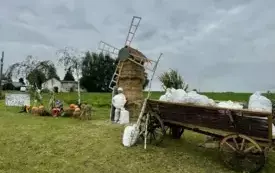 Sołectwo Brzozowo. Witacz przedstawający młyn przy kt&oacute;rym stoi gospodarz, w&oacute;z z workami mąki