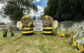 Sołectwo Bajerze. Witacz przestawiający dwie pszczoły stojące przy ulach