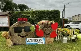 Witacz Sołectwo Szymborno. Witacz przedstawiający uśmiechnięte i zakochane buźki