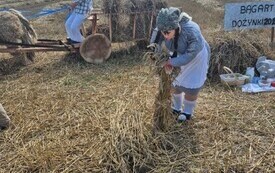 Witacz przedstawiający rolnik&oacute;w pracujących na polu. Jeden jedzie na powozie a na przodzie kobieta stawia sztygi