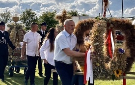 Ludzie niosący wieńce dożynkowe w korowodzie dożynkowym