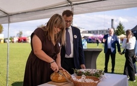 U boku starosty dożynek gminno-parafialnych starościna kroi chleb