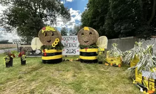 Sołectwo Bajerze. Witacz przestawiający dwie pszczoły stojące przy ulach